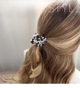 Détail de la pince à cheveux fleurie avec motif marbré noir et blanc et cristal au centre