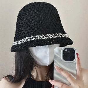 Detailed macro view of the black crochet bucket hat featuring white wavy pattern texture