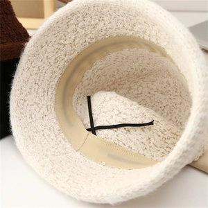 Detailed interior of a white fleece bucket hat showing adjustable inner cord and beige lining