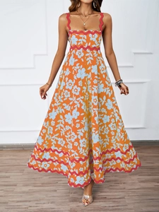 Detail of orange floral maxi dress featuring red scalloped trim and bohemian print design