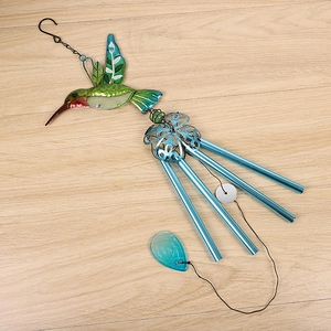 Detailed shot of a colorful glass hummingbird wind chime with four blue aluminum tubes