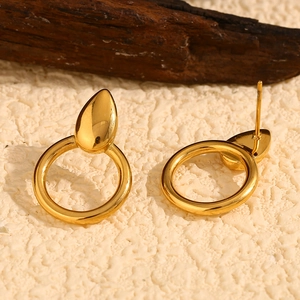 Detail view of 18K gold plated stainless steel teardrop and hoop earrings on wood background