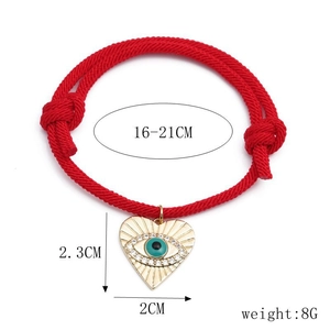Detail view of red braided bracelet with evil eye heart pendant and dimensions