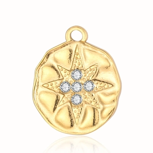 Detail of round gold pendant with embossed star pattern and inlaid clear rhinestones