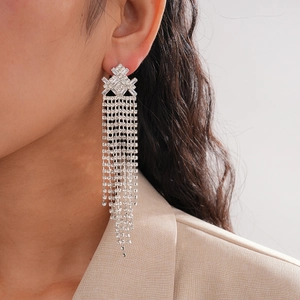 Close-up of geometric rhinestone tassel earrings worn by a model in elegant style