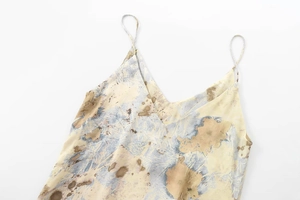 Détail d'une robe en satin de soie avec col en V, imprimé abstrait et fines bretelles