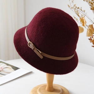 Detail of burgundy wool cloche hat with a brown leather belt strap and gold buckle