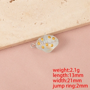 Dettaglio macro del ciondolo a conchiglia traslucida con accenti dorati per gioielli DIY