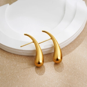 Minimalist 18K gold teardrop earrings with a glossy metallic finish on a white stand