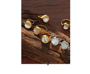 Macro shot of lava-textured gold and silver rings with mother of pearl on wood