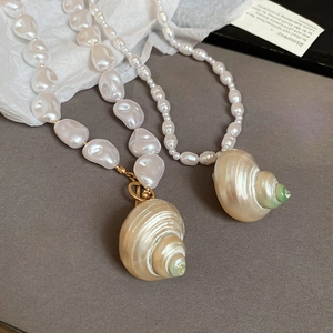 Detail of elegant shell pendant necklaces with baroque pearls and gold fasteners