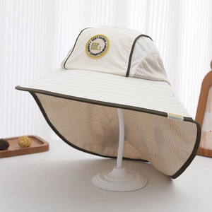 Detailed close-up of side mesh panels and round badge on large brim kids sun hat
