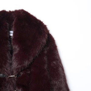 Dettaglio cappotto bordeaux in pelliccia sintetica con colletto e cinturino in pelle