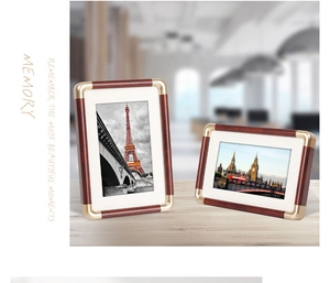 Detail of red-brown wood grain photo frames with luxury gold metal rounded corners