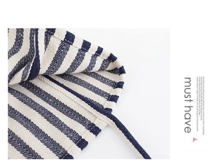 Macro detail of high-quality striped canvas texture and fine stitching on the tote bag