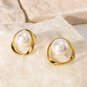Elegant gold stainless steel earrings with pearl inlay on white textured stone surface
