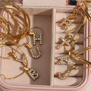 Macro view of 18K gold-plated double-layer necklaces with sparkling zircon initial charms