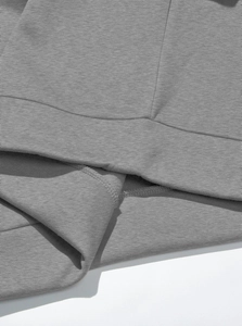 Close-up of grey fleece fabric texture and fine stitching on the half-zip sweatshirt