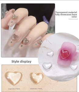 Macro detail of transparent resin heart nail charms in 6mm and 5.5mm sizes