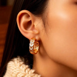 Detail of 18K gold plated coin pattern earrings featuring sparkling zircon inlay on model