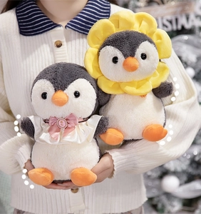Close-up of plush penguin toys with sunflower headpiece and lace bow details