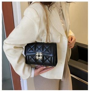 Close-up of black quilted leather handbag with gold chain strap and elegant metal buckle