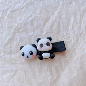 Detailaufnahme der süßen Panda-Haarklammer mit 3D-Harzfiguren auf schwarzem Band