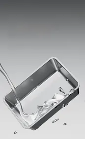 Vue macro d'eau sur la surface anti-adhésive du bac à litière en acier inoxydable