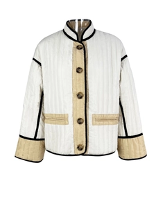 Detail of white quilted jacket with beige contrast trim and large brown buttons