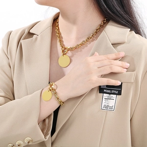 Golden 9mm stainless steel chain necklace and bracelet set with round pendant on model