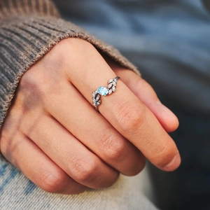 Close-up of S925 silver leaf ring with light blue oval gemstone on hand