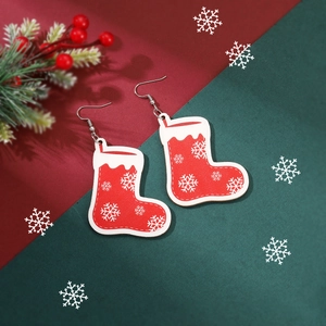 Detail of red Christmas sock earrings with white snowflake patterns and metal hooks