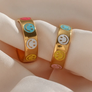 18K gold plated hoop earrings with colorful enamel smiley face patterns on silk background
