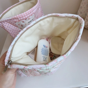 Détail de la trousse de toilette matelassée à fleurs montrant sa grande capacité
