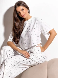 Détail d'un pyjama blanc avec des motifs de cœurs noirs et un tissu en maille douce
