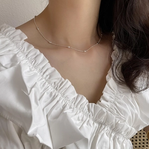 Minimalist 925 sterling silver olive bead necklace worn on model neck for elegance