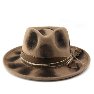 Detail of vintage fedora hat with burnt effect, woven rope, and feather accessory
