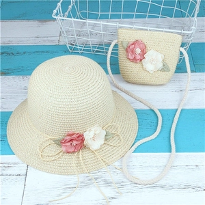 Détail d'un chapeau de paille crème et sac assorti avec des ornements floraux roses