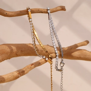 Detail of gold and silver tennis bracelets with 3mm zircons on rustic wood branch