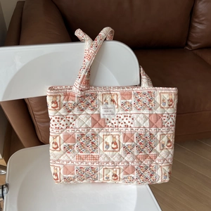 Detailed patchwork floral quilted tote with cute bunny illustration on white chair