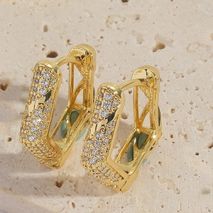 Close-up of gold-plated U-shaped earrings with micro-pave cubic zirconia crystals
