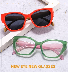 Close-up of cat-eye frames in orange and transparent green with detailed temple markings
