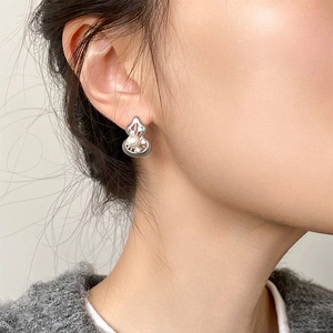 Close-up of model wearing silver hollow gourd earrings with pearls and zircon details