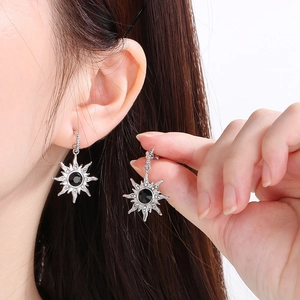 Détails des boucles d'oreilles étoile en argent avec pierre noire et petits diamants