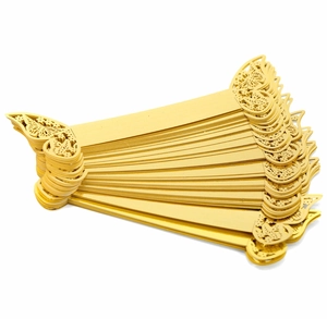 Macro shot of laser-cut gold butterfly napkin rings stacked on a white background