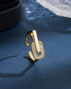 Macro view of gold French enamel ring featuring white inlay and sparkling side diamonds