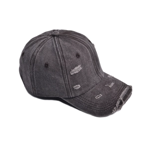 Detailed view of distressed baseball cap with frayed holes and washed vintage finish