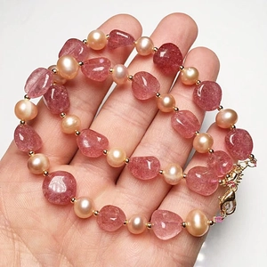 Macro detail of strawberry crystal and freshwater pearl bracelet with 14K gold clasp