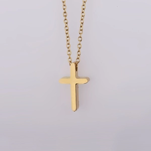 Detailed view of a polished gold stainless steel cross pendant on a delicate O-chain