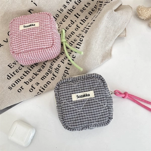 Dettaglio mini pochette a scacchi trapuntata con cordino vivace e chiusura a zip